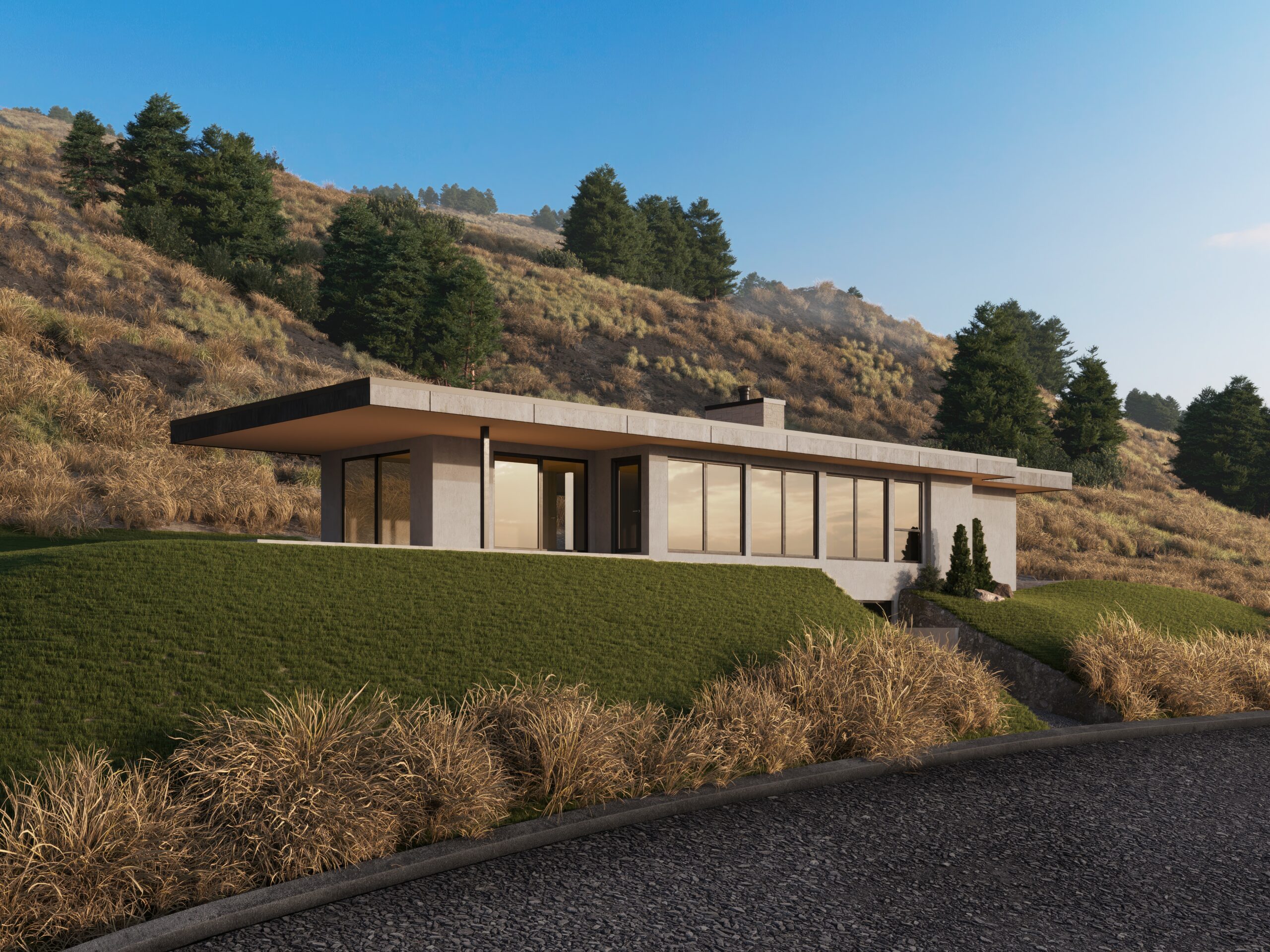 Image of the exterior of a home with green grass and a hillside behind. The house has many windows and a flat roof.