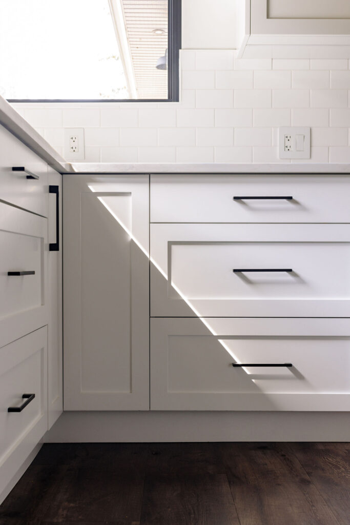 Image showing the detailed shaker style kitchen cabinets with black metal handles.