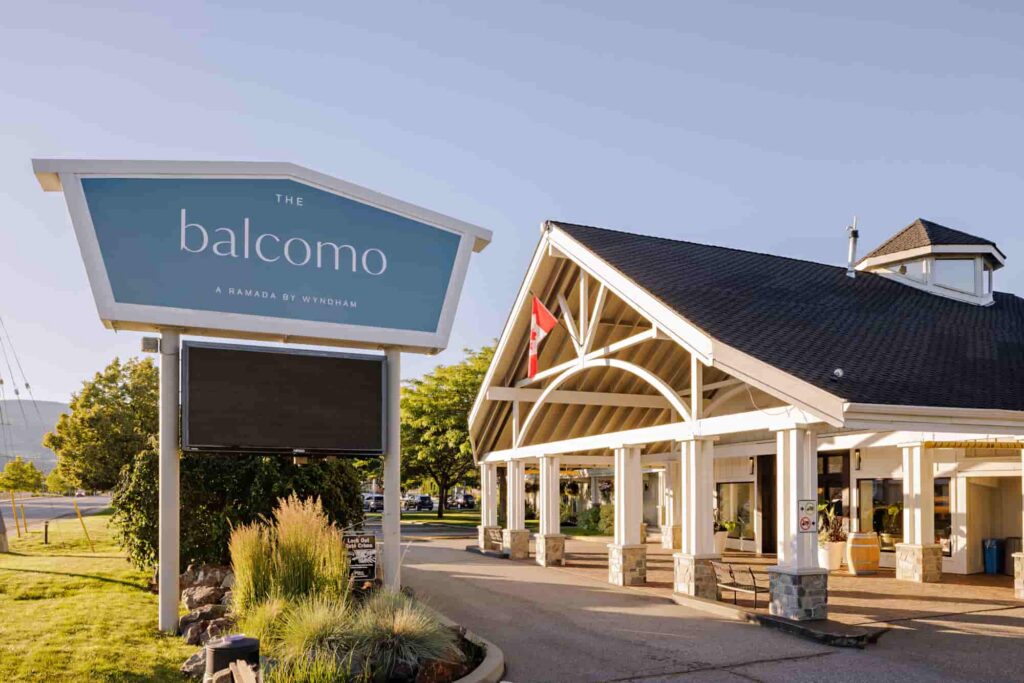 Exterior of The Balcomo hotel in Penticton, BC, with the main entrance and roadside sign